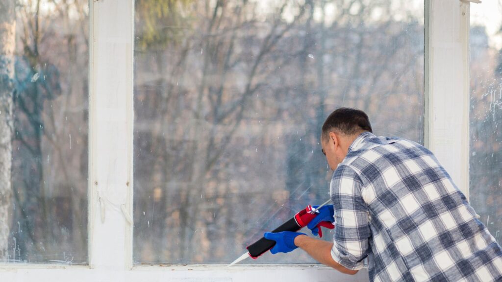 A man using a sealing gel gun to upgrade cooling system of his house